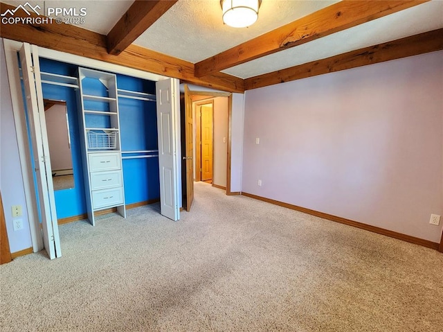 unfurnished bedroom featuring baseboards, beam ceiling, carpet, and baseboard heating