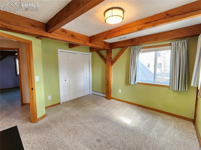 unfurnished bedroom with beam ceiling, a textured ceiling, a closet, baseboards, and baseboard heating