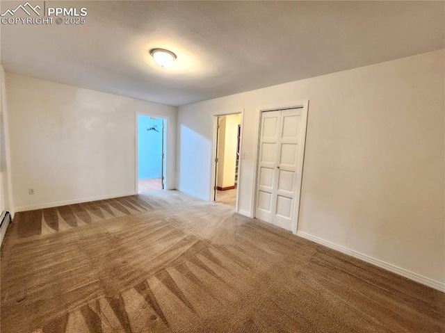 carpeted empty room featuring baseboards