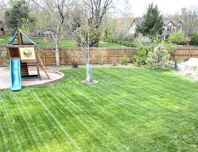 view of yard with a fenced backyard and a playground