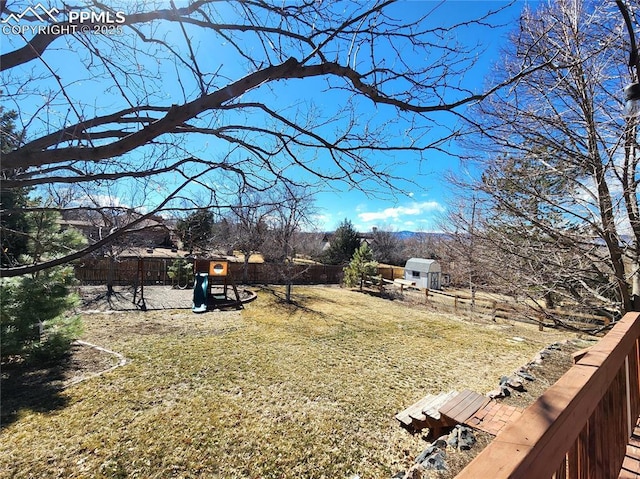 view of yard featuring fence and a playground