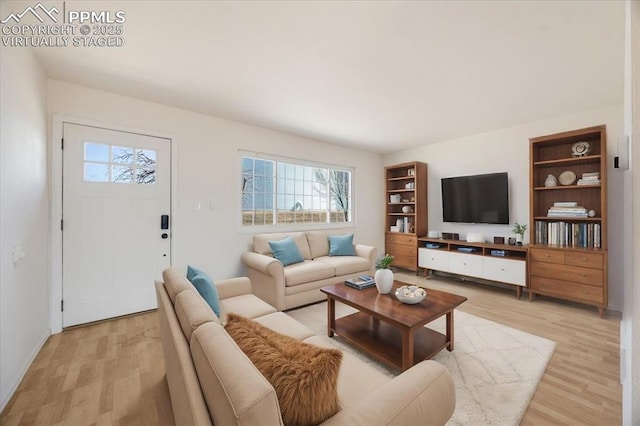 living area with built in shelves and light wood-style flooring