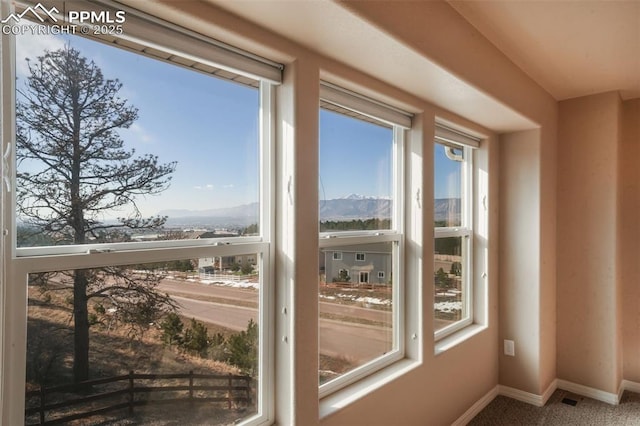 interior space with a mountain view, baseboards, and carpet flooring