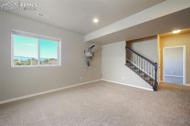 spare room featuring visible vents, stairway, carpet, and baseboards