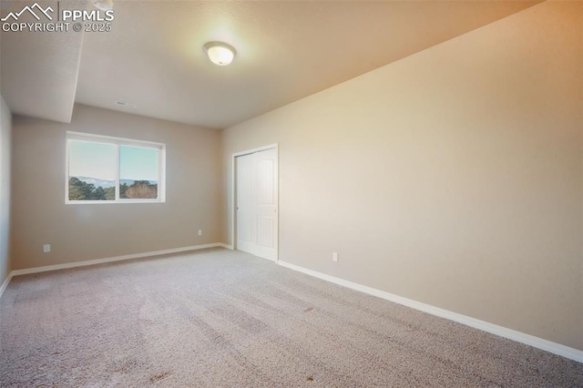 unfurnished room featuring baseboards and carpet floors