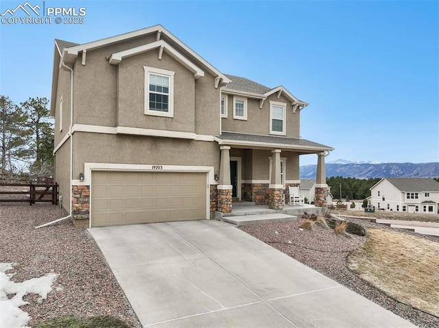 view of front of property featuring concrete driveway, covered porch, stone siding, and stucco siding