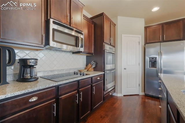 kitchen featuring light stone counters, stainless steel appliances, backsplash, and dark wood-style flooring