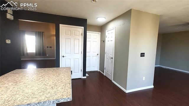 interior space featuring dark wood-style flooring and baseboards