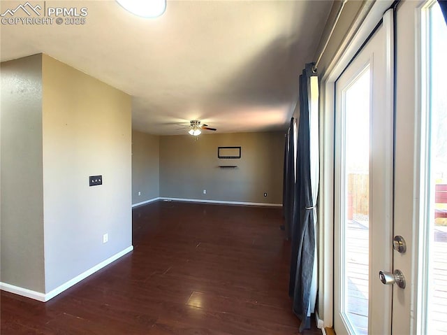 hallway featuring dark wood finished floors and baseboards