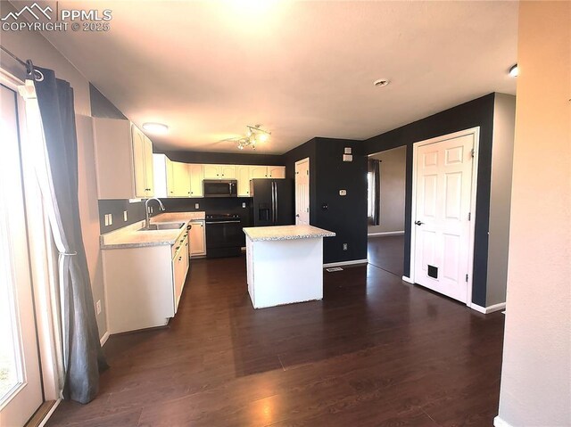 kitchen with stove, dark wood-type flooring, black refrigerator with ice dispenser, light countertops, and a sink