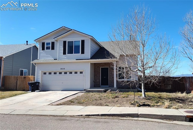 traditional-style house featuring driveway, brick siding, an attached garage, and fence