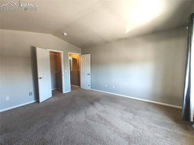 unfurnished bedroom featuring lofted ceiling, baseboards, and carpet flooring