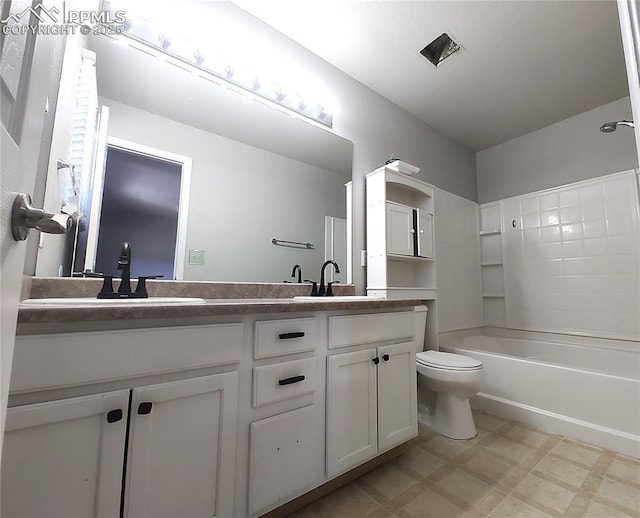 full bathroom featuring double vanity, shower / bathing tub combination, a sink, and toilet