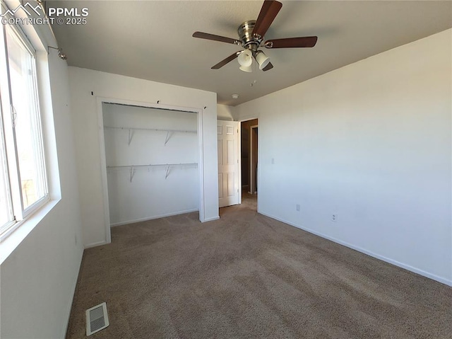 unfurnished bedroom featuring a closet, visible vents, a ceiling fan, carpet flooring, and baseboards