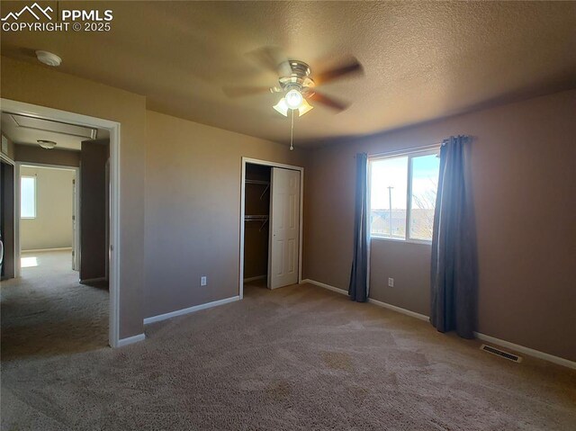 unfurnished bedroom featuring a textured ceiling, carpet floors, a closet, and baseboards