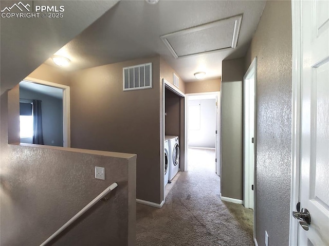 hallway with attic access, visible vents, washer and clothes dryer, an upstairs landing, and carpet floors