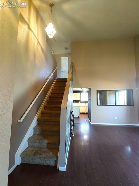 stairs featuring wood finished floors and baseboards