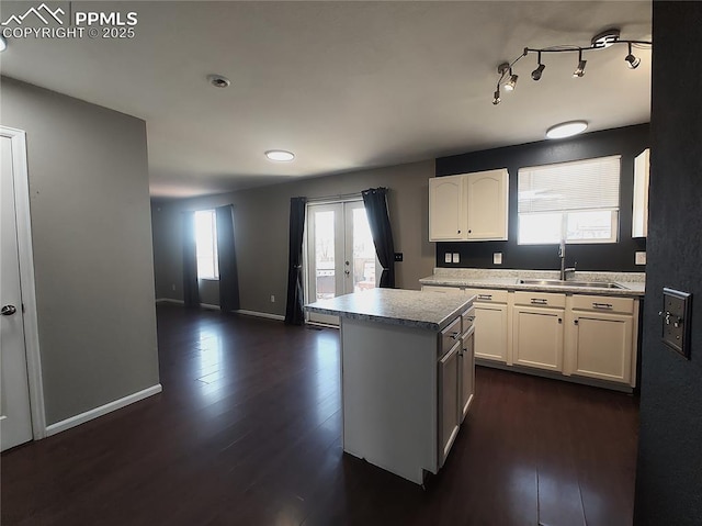 kitchen with dark wood-type flooring, french doors, white cabinetry, and a sink