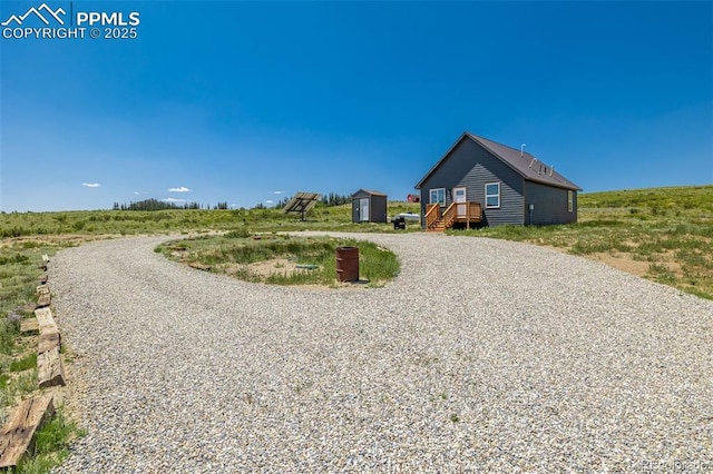 view of front of home featuring curved driveway and an outdoor structure