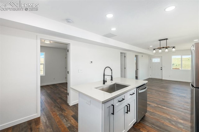 kitchen with a center island with sink, dark wood finished floors, open floor plan, stainless steel appliances, and a sink