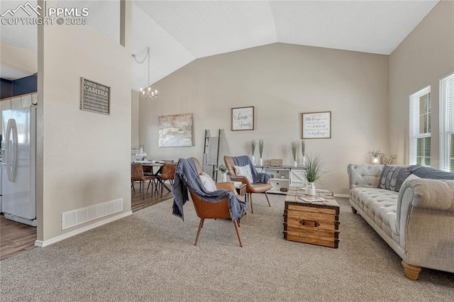 living room with visible vents, a chandelier, baseboards, carpet, and high vaulted ceiling