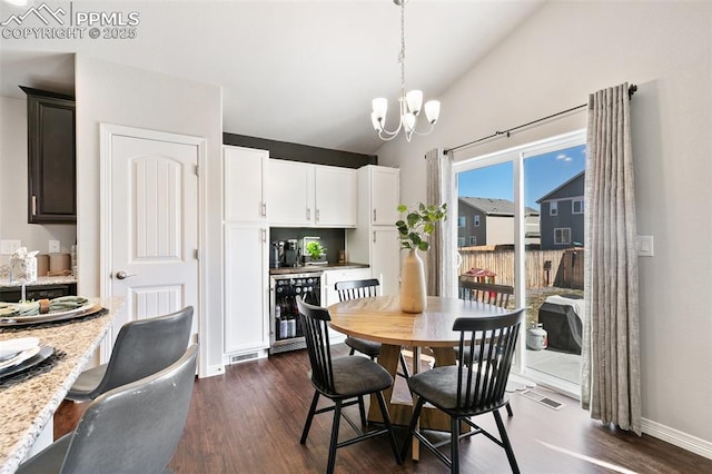 dining space with visible vents, dark wood finished floors, lofted ceiling, wine cooler, and a chandelier