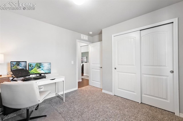 carpeted office space featuring visible vents and baseboards