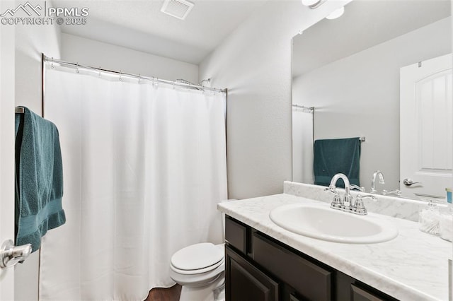 bathroom featuring visible vents, vanity, and toilet