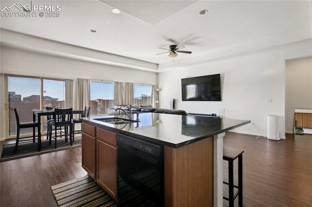 kitchen with ceiling fan, a breakfast bar, dark wood-style flooring, a sink, and dishwasher