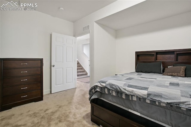 bedroom featuring visible vents and light colored carpet