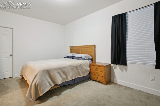 bedroom with light carpet and baseboards