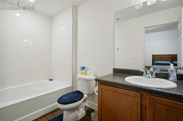 ensuite bathroom with ensuite bathroom, toilet, shower / bath combination, wood finished floors, and vanity