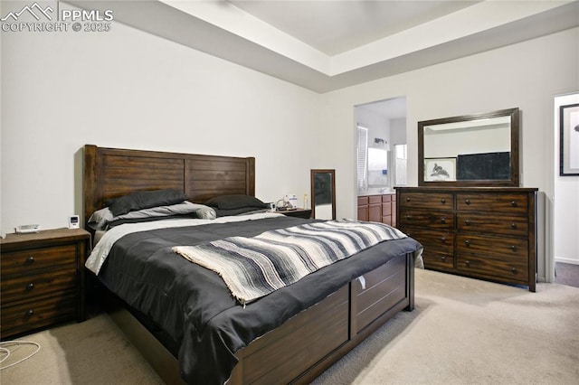 bedroom featuring light carpet and a tray ceiling