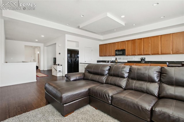 living area featuring dark wood-style flooring and recessed lighting