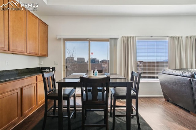 dining space with dark wood-style flooring and baseboards