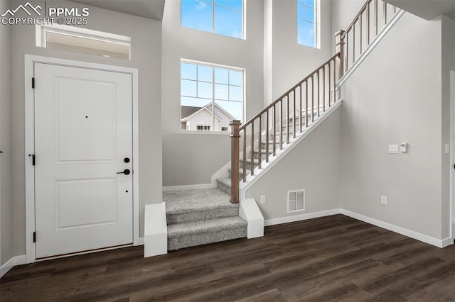 6395 Laud Pt, Colorado Springs, CO 80924 - foyer with stairs, dark wood-style floors, baseboards, and a towering ceiling