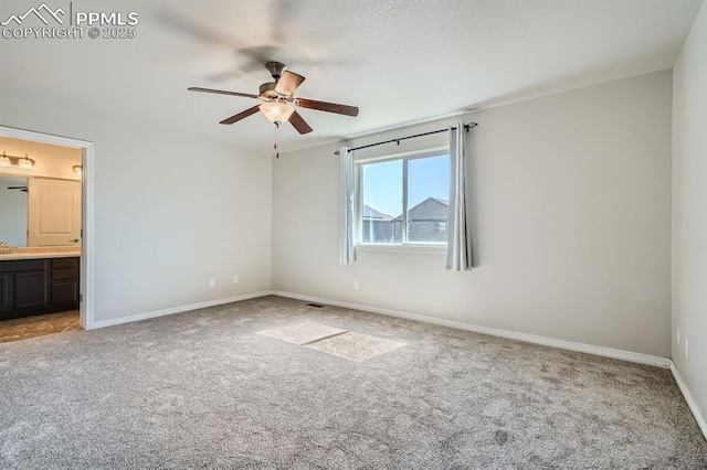 unfurnished bedroom featuring carpet flooring, ceiling fan, baseboards, and ensuite bathroom