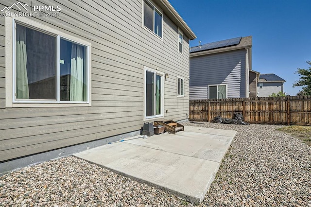 back of house featuring entry steps, fence, and a patio