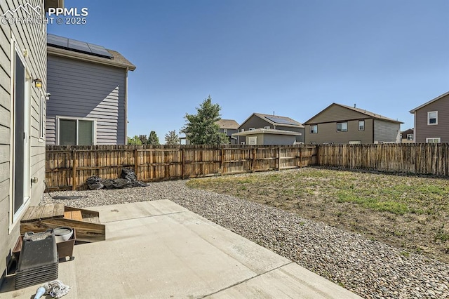 view of yard with a patio area, a fenced backyard, and a residential view