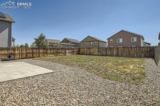 view of yard with a patio, a fenced backyard, and a residential view