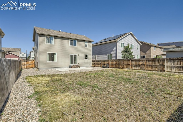 rear view of property with a yard, a patio area, and a fenced backyard