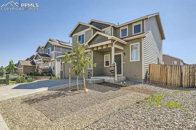 craftsman-style home with a residential view, fence, and concrete driveway