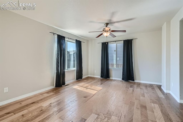 unfurnished room featuring a ceiling fan, baseboards, and light wood finished floors