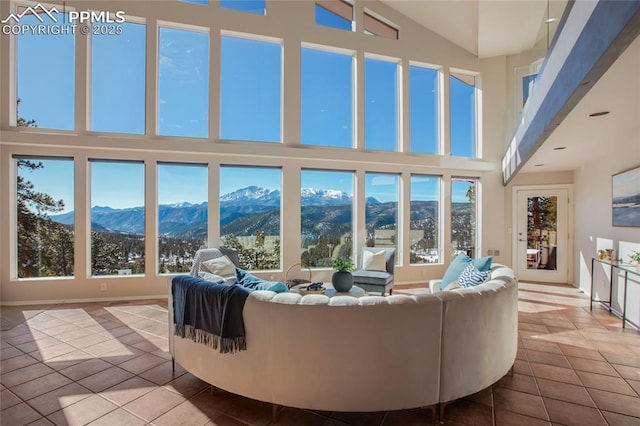 living area with a mountain view, a high ceiling, and tile patterned floors