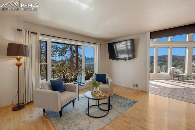 living area with visible vents and hardwood / wood-style floors