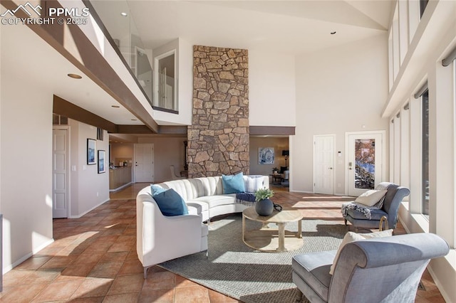 living area featuring a high ceiling and baseboards