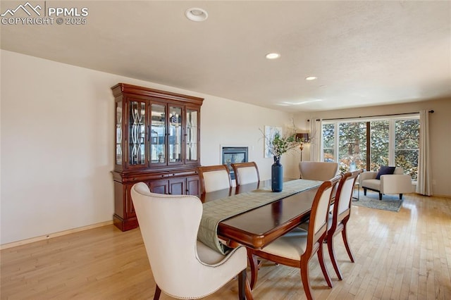 dining space featuring baseboards, light wood-style flooring, and recessed lighting