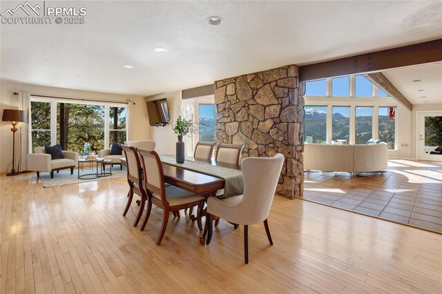 dining area with beamed ceiling and light wood-style floors