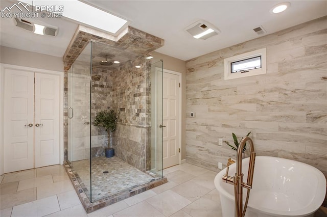 full bathroom featuring a stall shower, visible vents, and a freestanding bath