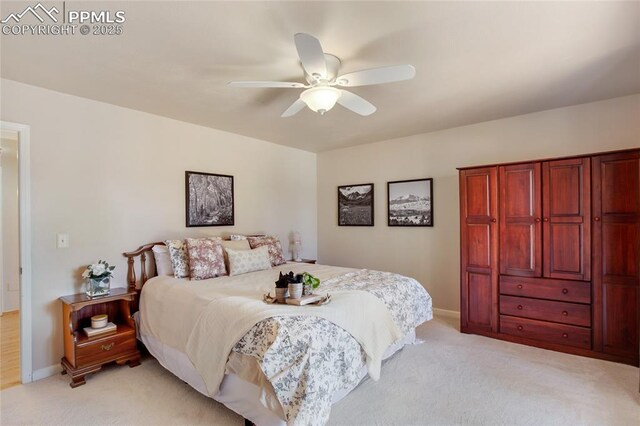 bedroom with light carpet, ceiling fan, and baseboards